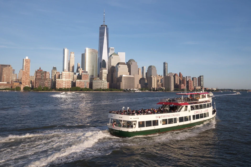 The Circle Line Sightseeing Cruise passing through the Manhattan skyline  at midday