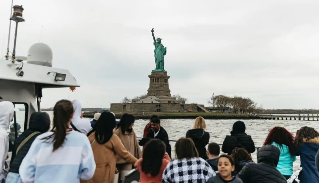 Tourists taking photos of the Liberty Statue from the cruise