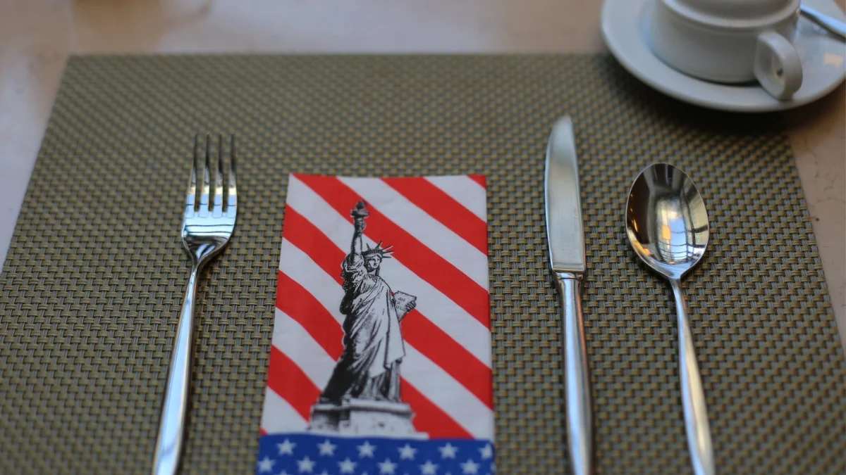 A napkin featuring the Statue of Liberty, set on a dining table with silverware and a cup