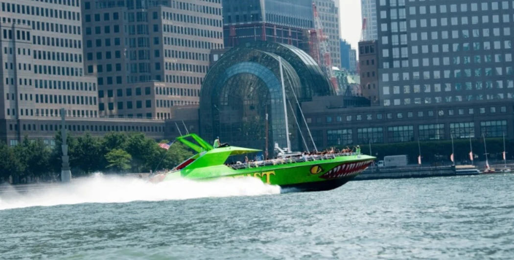 Speedboat passing by Winter Garden Atrium, located within Brookfield Place in New York City's Lower Manhattan