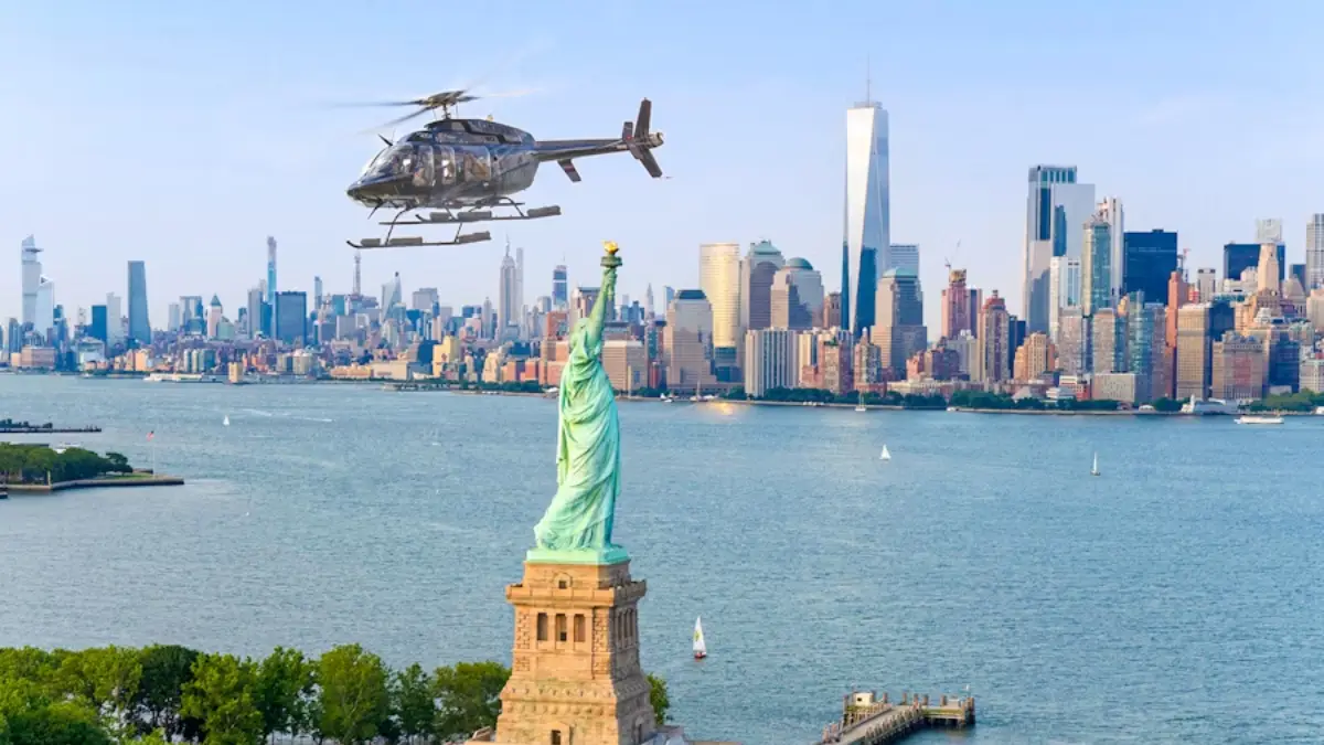 Helicopter flying over the Statue of Liberty with the NYC skyline in the background