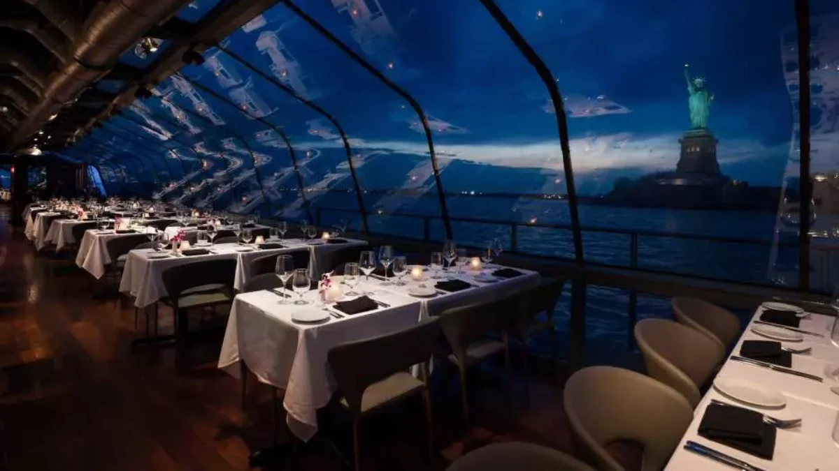 The tables inside the Liberty dinner cruise with Lady Liberty in the backdrop